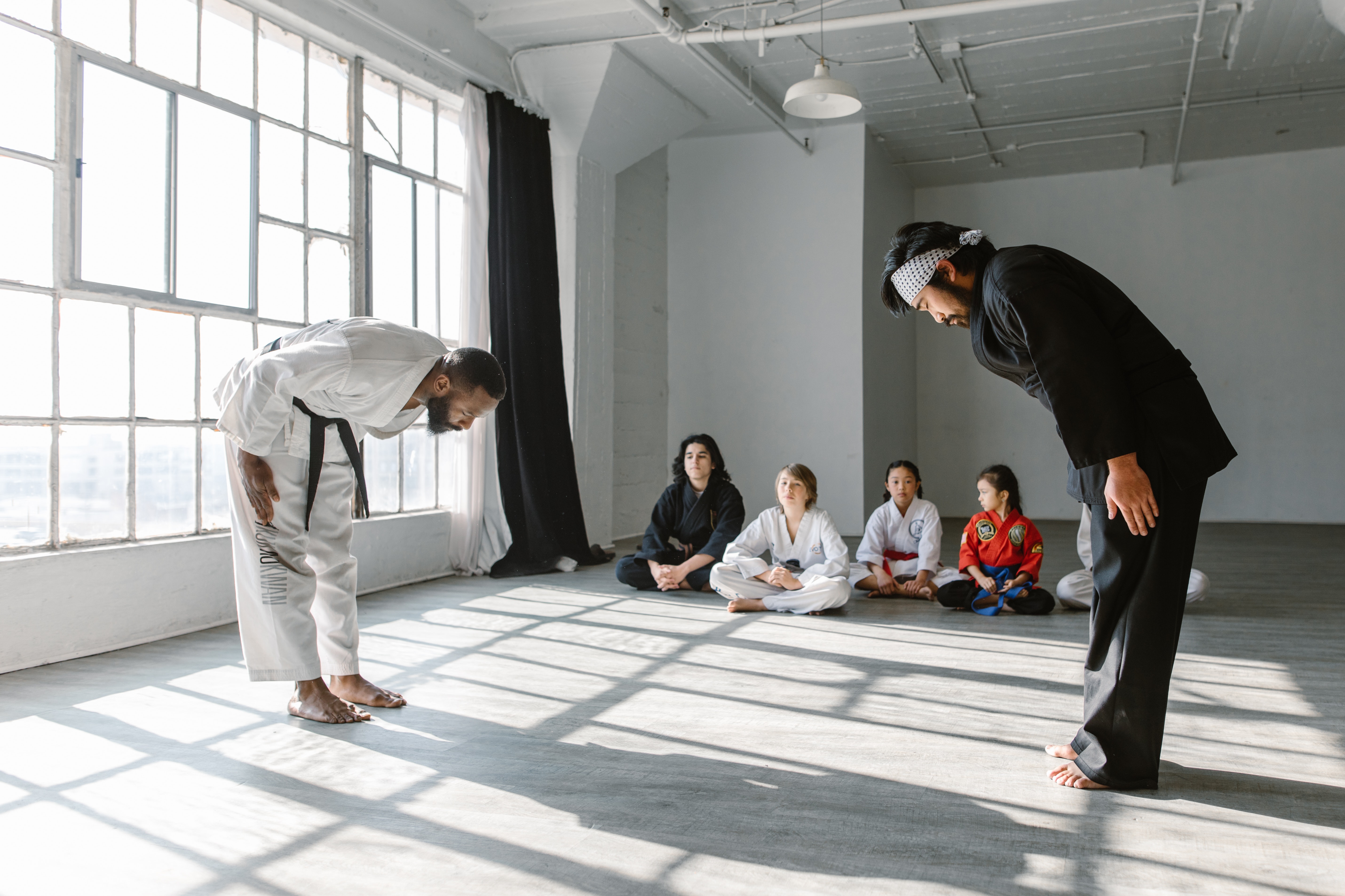 Sensei and student bowing to each other in front of other students